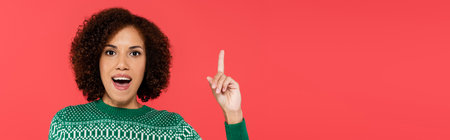 astonished african american woman showing idea sign and looking at camera isolated on red, banner