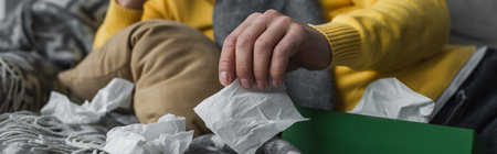partial view of sick man lying near crumpled paper napkins, banner