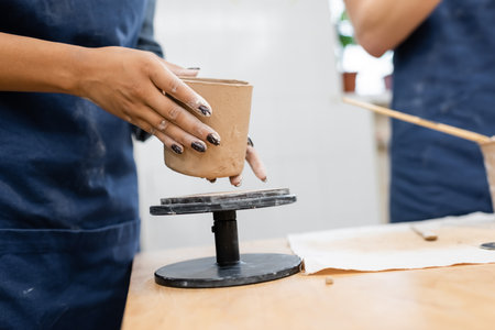 Cropped view of african american woman holding clay product in pottery studio