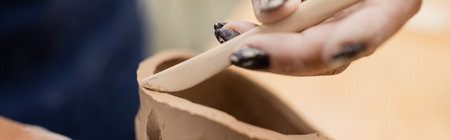 Close up view of african american master forming clay sculpture in pottery workshop, banner