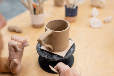 Cropped view of artisan making ceramic cup in pottery workshopの写真素材
