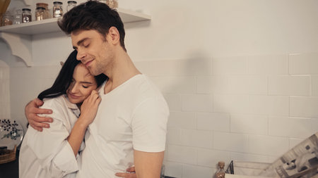 sensual young woman in white shirt hugging happy boyfriend in t-shirtの写真素材