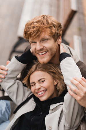 high angle view of cheerful young woman hugging smiling redhead manの写真素材