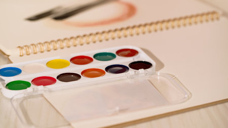 Close up view of watercolor paint on blurred sketchbook at homeの写真素材