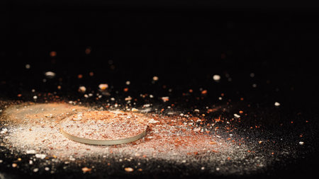 Colorful and cracked face powder on black background with copy space