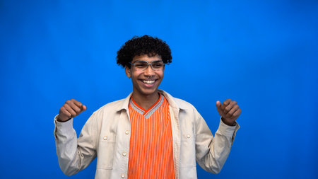 Cheerful african american man in eyeglasses looking away isolated on blue