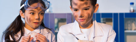 kids with dirty faces looking at blurred tweezers in chemical lab, bannerの写真素材