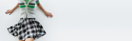 Top view of young woman in striped cardigan and skirt on grey background, bannerの写真素材