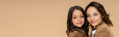 trendy mother and child smiling at camera isolated on beige, bannerの写真素材