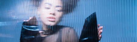 pretty african american model in black outfit looking away through ruffled glass, banner