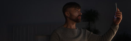 man searching mobile signal on smartphone during energy blackout, bannerの写真素材