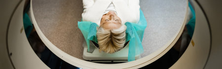 high angle view of woman with closed eyes doing diagnostics on ct scanner, bannerの写真素材