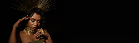 young african american woman with golden necklace and crown posing isolated on black, banner