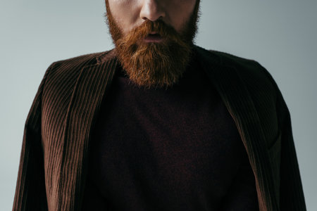 cropped view of bearded man in turtleneck and blazer isolated on greyの写真素材