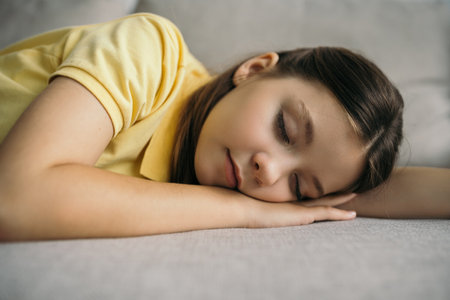 tired preteen girl sleeping on sofa at home