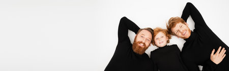 top view of cheerful bearded man with red haired son and grandson smiling at camera while lying on light grey background, bannerの写真素材