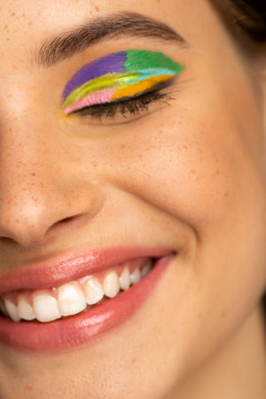 Close up view of smiling teenager with freckles and colorful visageの写真素材