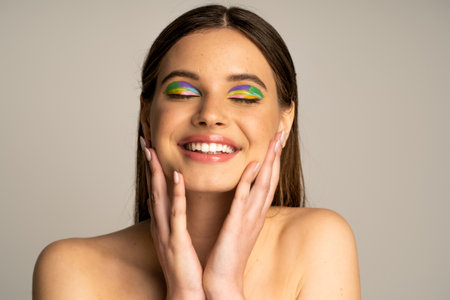 Teen model with bright visage touching face isolated on greyの写真素材