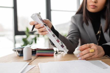 Cropped view of blurred designer holding color samples in studio shotの写真素材