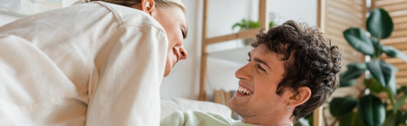 happy young couple laughing while looking at each other, bannerの写真素材