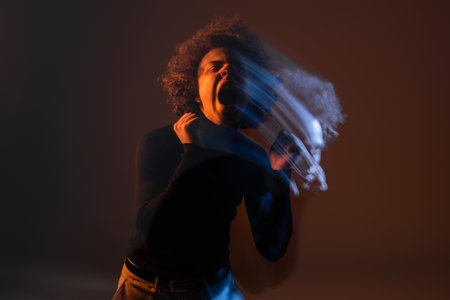 double exposure of angry african american man with bipolar disorder screaming on dark background...