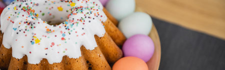 Delicious Easter bread and painted pastel colors eggs on table, bannerの写真素材
