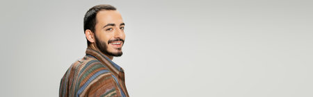 portrait of happy bearded man in colorful shirt smiling at camera isolated on grey, bannerの写真素材