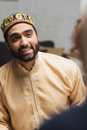 Smiling muslim man looking at blurred wife at homeの写真素材