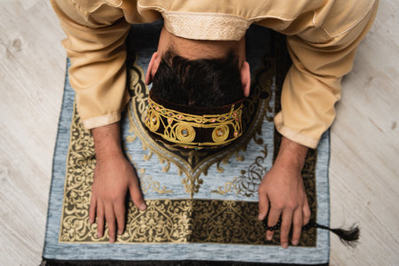 Overhead view of muslim man praying on rug at homeの写真素材