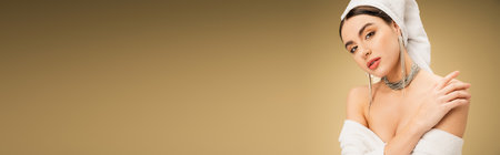 sensual woman with makeup and white towel on head touching bare shoulder on beige background, bannerの写真素材