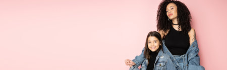 Trendy preteen kid holding hand of curly mom isolated on pink, banner