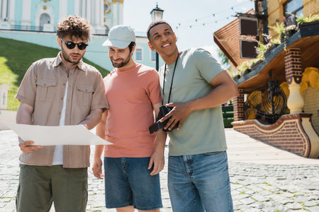 young tour guide showing city map to multiethnic travelers on Andrews descent in Kyivの写真素材
