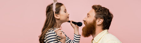 Preteen kid in headband holding makeup brush near bearded dad isolated on pink, bannerの写真素材