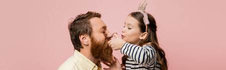 Child with crown headband curling eyelashes of father isolated on pink, bannerの写真素材