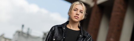 young blonde woman in stylish outfit walking with handbag on street in Miami, bannerの写真素材