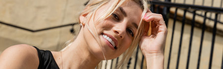 sunshine on face of cheerful woman with blonde hair smiling outside, bannerの写真素材