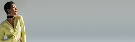 Fashionable african american woman with red lips posing isolated on grey with copy space, bannerの写真素材