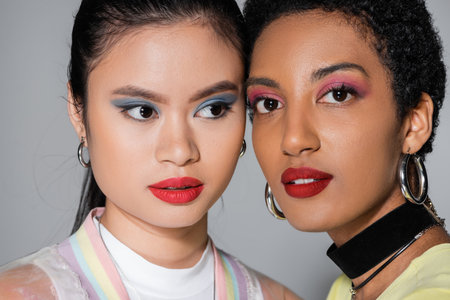 Portrait of interracial models with colorful makeup on grey backgroundの写真素材