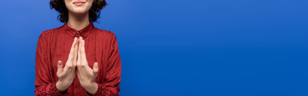cropped view of smiling woman showing gesture meaning happy on sign language isolated on blue, bannerの写真素材
