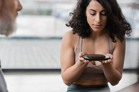 middle eastern woman looking at plate with compressed puer tea in yoga studioの写真素材