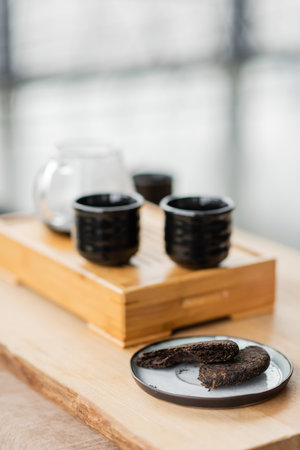 compressed pu-erh tea on plate near Japanese tea cups in yoga studioの写真素材
