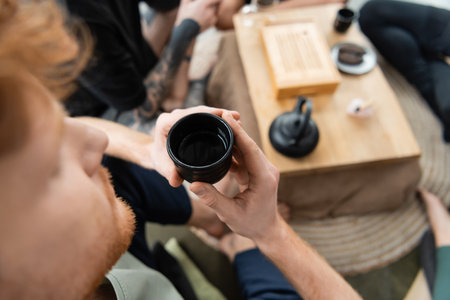 top view of redhead man holding Chinese cup with brewed puer teaの写真素材