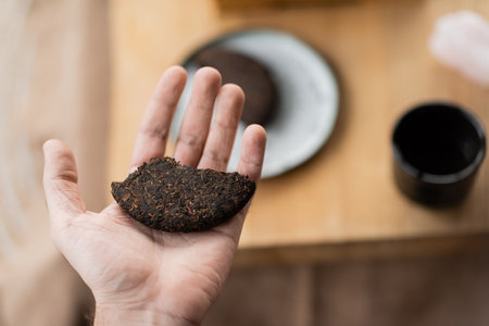 top view of man holding piece on compressed puer tea in handの写真素材