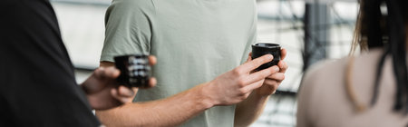 cropped view of people holding japanese cups with puer tea in yoga studio, bannerの写真素材