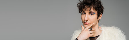 portrait of brunette pansexual model in white faux fur jacket and silver accessories isolated on grey, bannerの写真素材