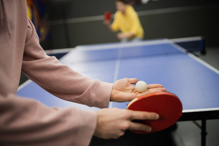 Cropped view of man holding racket and ball while playing table tennis in gaming clubの写真素材