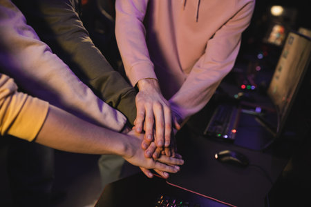Cropped view of multiethnic team holding hands in cyber clubの写真素材