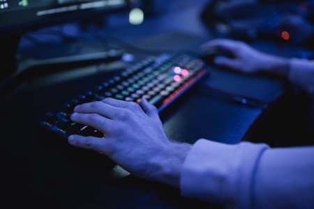 Cropped view of man playing video game on computer on cyber clubの写真素材