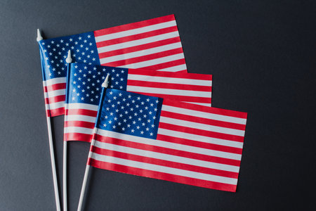 top view of three flags of America with stars and stripes isolated on blackの写真素材