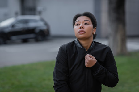 multiracial woman with psychological problem wearing jacket on urban streetの写真素材
